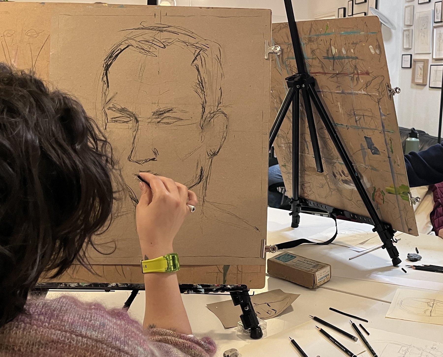 Participant drawing a portrait study on toned paper